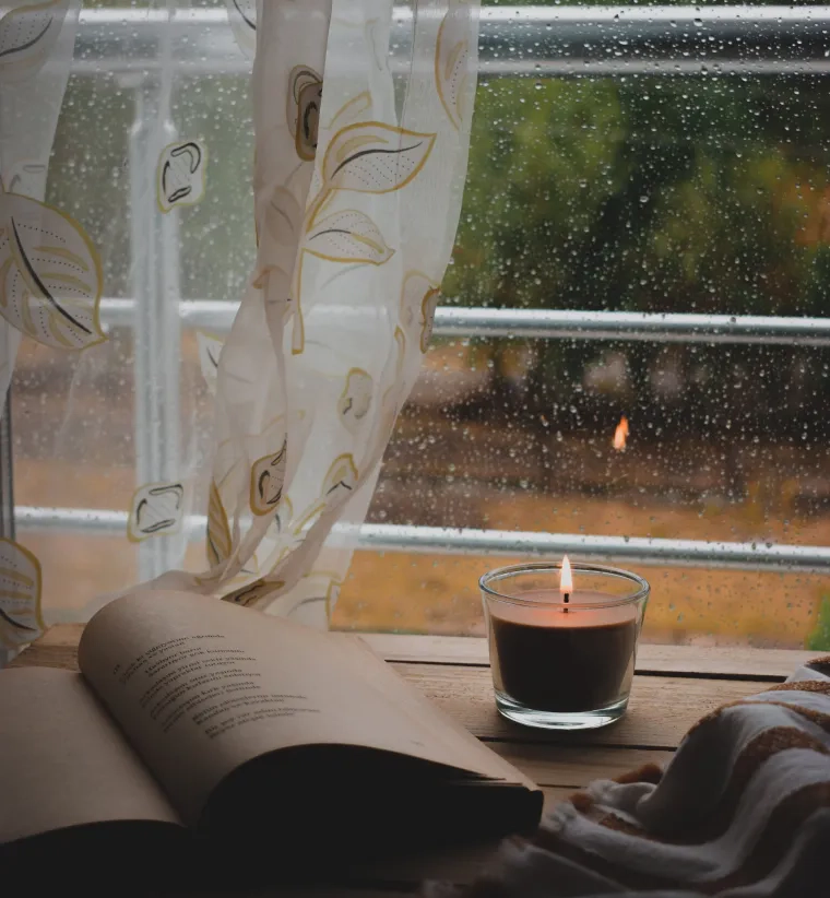 book and a candle in front of a window